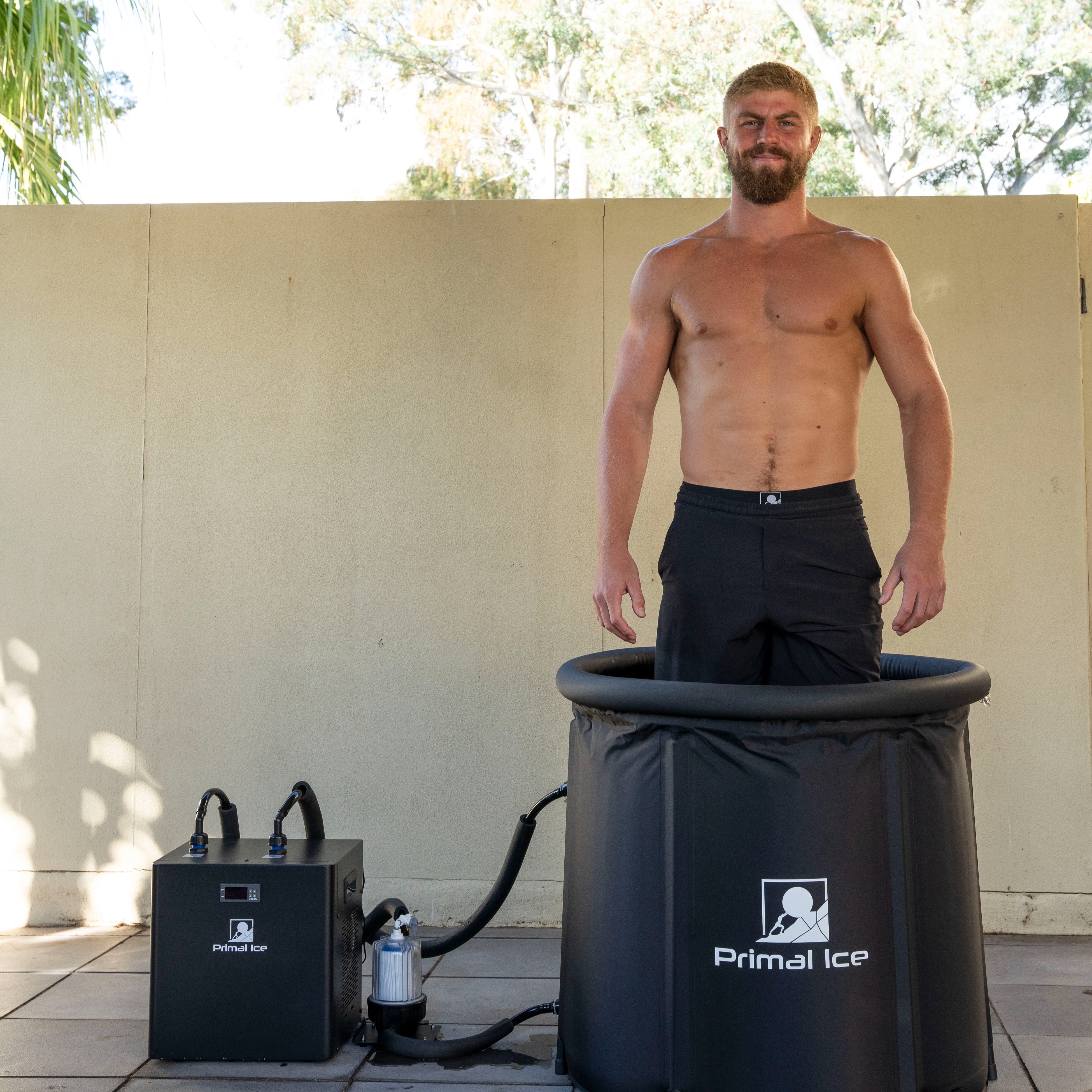 Man inside ice bath tub with chiller connected