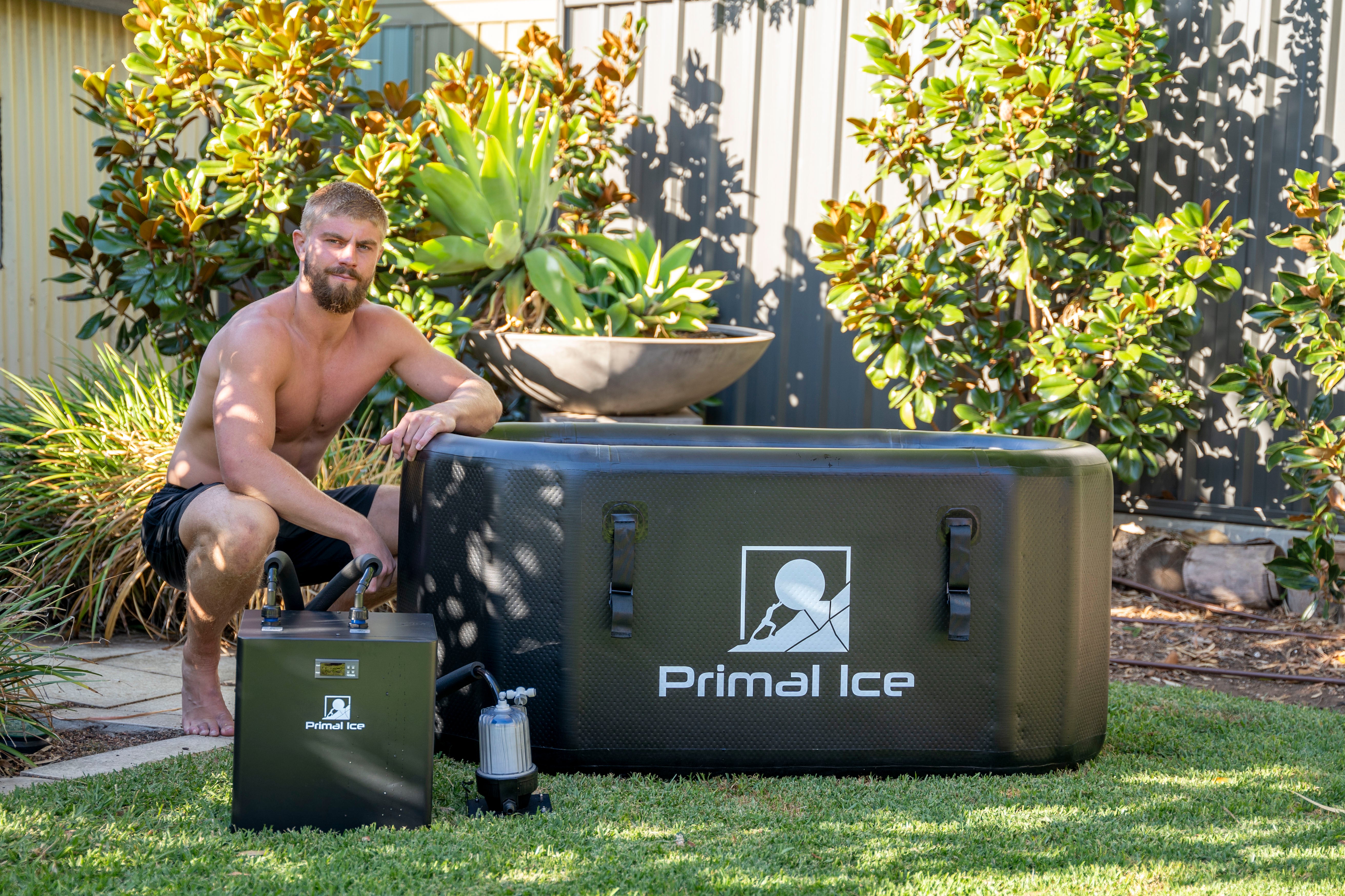 man sitting by ice bath tub and chiller unit