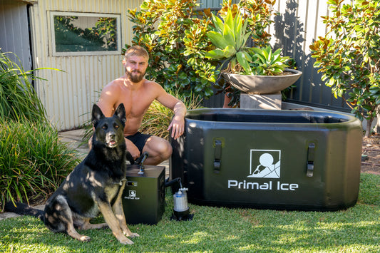 man and dog sitting next to ice bath tub and chiller unit